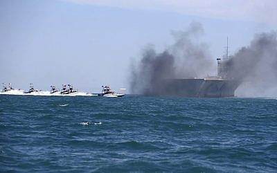 Sur cette photo de l'agence de presse iranienne semi-officielle, les bateaux des gardiens de la révolution prennent d'assaut une réplique de navire porte-avions américain pendant des exercices à grande échelle près de l'entrée du Golfe persique, le 25 février 2015 (Crédit :  AP/Fars News Agency, Hamed Jafarnejad)