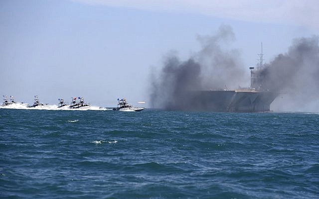 Sur cette photo de l'agence de presse iranienne semi-officielle, les bateaux des gardiens de la révolution prennent d'assaut une réplique de navire porte-avions américain pendant des exercices à grande échelle près de l'entrée du Golfe persique, le 25 février 2015 (Crédit : AP/Fars News Agency, Hamed Jafarnejad) Sur cette photo de l'agence de presse iranienne semi-officielle, les bateaux des gardiens de la révolution prennent d'assaut une réplique de navire porte-avions américain pendant des exercices à grande échelle près de l'entrée du Golfe persique, le 25 février 2015 (Crédit : AP/Fars News Agency, Hamed Jafarnejad)