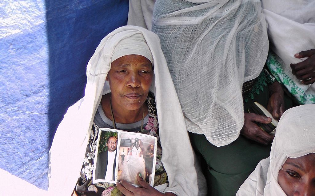 Une Ethiopienne à la synagogue d'Addis Abeba priant et tenant les photos de membres de sa famille vivant en Israël. (Crédit : Bernard Dichek/ Times of Israel) Une Ethiopienne à la synagogue d'Addis Abeba priant et tenant les photos de membres de sa famille vivant en Israël. (Crédit : Bernard Dichek/ Times of Israel)