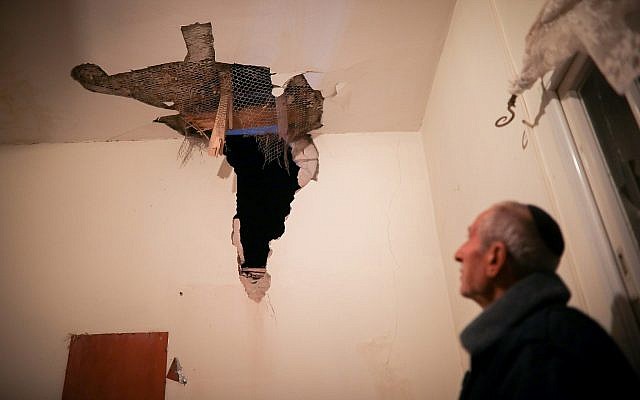 Un homme inspecte les dégâts causés à sa maison par une roquette tirée depuis la bande de Gaza, dans la ville de Sdérot, au sud d'Israël, près de la frontière avec Gaza, le 25 mars 2019. (Hadas Parush/Flash90)