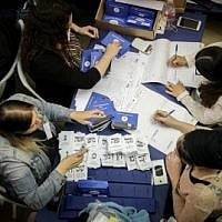 Des Israéliens dépouillent les bulletins de vote encore en attente des soldats et des électeurs de l'étranger au Parlement de Jérusalem, au lendemain des élections générales, le 10 avril 2019. (Noam Revkin Fenton/Flash90)