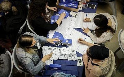 Des Israéliens dépouillent les bulletins de vote encore en attente des soldats et des électeurs de l'étranger au Parlement de Jérusalem, au lendemain des élections générales, le 10 avril 2019. (Noam Revkin Fenton/Flash90)