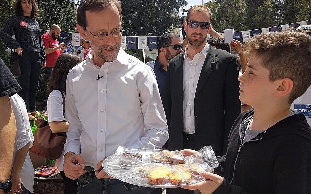 Des élèves de Sixième de Tel Aviv organisent une vente de pâtisseries pour collecter des fonds pour leur fête de fin d'année et proposent leurs pâtisseries au candidat du parti Zehut Moshe Feiglin devant un bureau de vote, le 9 avril 2019. Feiglin n'a pas acheté de pâtisseries. (Melanie Lidman/Times of Israel)