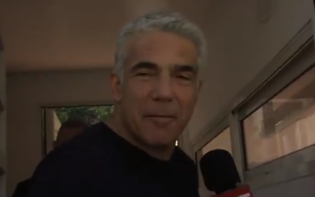 Yair Lapid, numéro 2 de Kakhol lavan, s'entretient avec un journaliste de la Douzième chaîne devant son domicile à Tel Aviv, le 10 avril 2019. (Capture d'écran : Douzième chaîne)