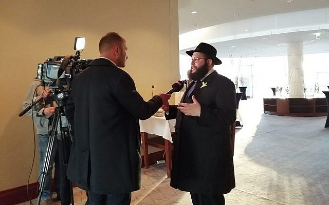 Le Rabbin Shalom Ber Stambler 'adresse aux médias polonais avant le crépuscule avant de fêter avec des centaines de personnes le tout premier seder dans l'ancien ghetto de Varsovie depuis sa destruction en 1943 à l'hôtel Hilton, le 19 avril 2019 (Autorisation : Mouvement 'Habad de Varsovie)