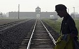 Dans cette photo du 29 juillet 2016, un homme traverse la tristement célèbre voie ferrée de l'ancien camp de la mort nazi d'Auschwitz-Birkenau en Pologne. (AP Photo/Alik Keplicz, FILE)