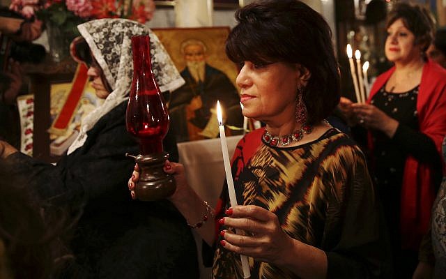 Des membres de l’Eglise catholique romaine prient lors de la procession du dimanche de Pâques à l’Eglise du Saint-Sépulcre dans la Vieille ville de Jérusalem, le 16 avril 2017. (Crédit : AFP / Gali Tibbon) Des membres de l’Eglise catholique romaine prient lors de la procession du dimanche de Pâques à l’Eglise du Saint-Sépulcre dans la Vieille ville de Jérusalem, le 16 avril 2017. (Crédit : AFP / Gali Tibbon)
