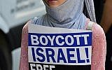 Une manifestante tenant un écriteau "Boycott d'Israël, Libérez la Palestine" lors de journée Al-Qods, à Berlin, le 9 juin 2018. (Crédit : AFP/Tobias Schwaez)