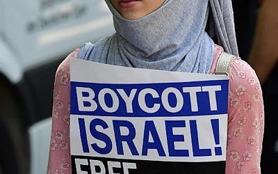 Une manifestante tenant un écriteau "Boycott d'Israël, Libérez la Palestine" lors de journée Al-Qods, à Berlin, le 9 juin 2018. (Crédit : AFP/Tobias Schwaez)