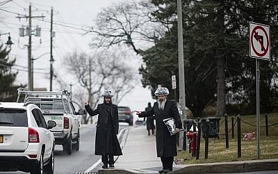 Illustration : Cette photo prise le 5 avril 2019 montre deux Juifs orthodoxes faisant de l'auto-stop sous la pluie dans un quartier juif de Monsey à Rockland County, New York. (Johannes Eisele/AFP)