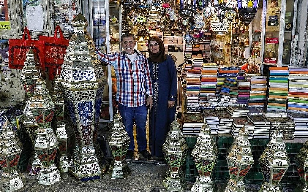 L'artisan palestinien Issam Zughair avec son épouse devant un étal de lanternes pour le Ramadan, dans la Vieille Ville de Jérusalem,, le 2 mai 2019 (Crédit : AHMAD GHARABLI / AFP)
