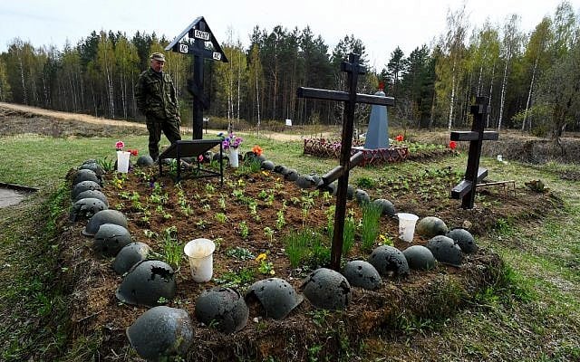Evguéni Ilyin, 64 ans, historien et chef du groupe de recherche de volontaires Ingria, se tient devant la tombe de soldats soviétiques tués pendant la Seconde Guerre mondiale, près de Sinyavino, à 50 km à l'est de Saint-Pétersbourg, le 5 mai 2019. (OLGA MALTSEVA / AFP)