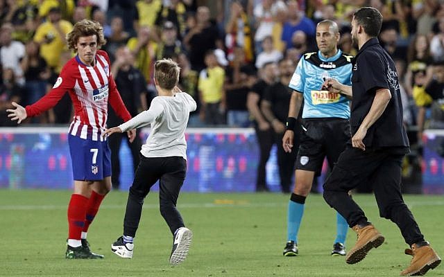 Un garçon court vers l'attaquant français Antoine Griezmann de l'Atletico Madrid lors du match de football amical opposant le Beitar Jerusalem à l'Atletico Madrid au stade Teddy de Jérusalem, le 21 mai 2019. (Crédit photo : Jack GUEZ / AFP)