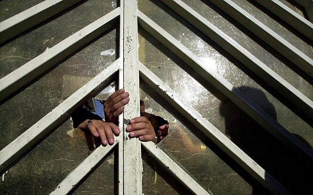 Les policiers iraniens ferment la porte du tribunal à Téhéran, le 17 juillet 2004 (Crédit : AP Photo/Vahid Salemi) Les policiers iraniens ferment la porte du tribunal à Téhéran, le 17 juillet 2004 (Crédit : AP Photo/Vahid Salemi)