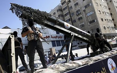 Des membres des brigades Al-Qods, la branche armée du Jihad islamique palestinien, avec un réplique d'une roquette durant une parade militaire, le 4 octobre 2018. (Crédit : AP/Adel Hana)