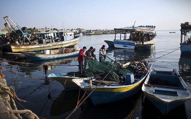Des pêcheurs palestiniens nettoient un filet après une nuit de pêche, au port de Gaza, le 3 avril 2019. (Crédit : AP/Khalil Hamra) Des pêcheurs palestiniens nettoient un filet après une nuit de pêche, au port de Gaza, le 3 avril 2019. (Crédit : AP/Khalil Hamra)