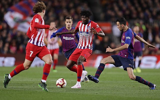 Antoine Griezmann et Thomas Partey, de l'Atlético et Sergio Busquets, (à droite) du FC Barcelone durant une match à Barcelone, le 6 avril 2019. (Crédit : AP Photo/Manu Fernandez) Antoine Griezmann et Thomas Partey, de l'Atlético et Sergio Busquets, (à droite) du FC Barcelone durant une match à Barcelone, le 6 avril 2019. (Crédit : AP Photo/Manu Fernandez)