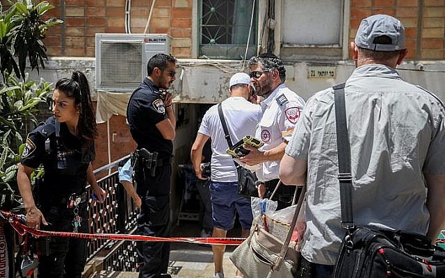 La police et les personnels médicaux sur les lieux d'un meurtre présumé après la découverte du corps d'un homme de 60 ans dans son appartement de Jérusalem, le 21 mai 2019 (Crédit : Noam Revkin Fenton/Flash90)