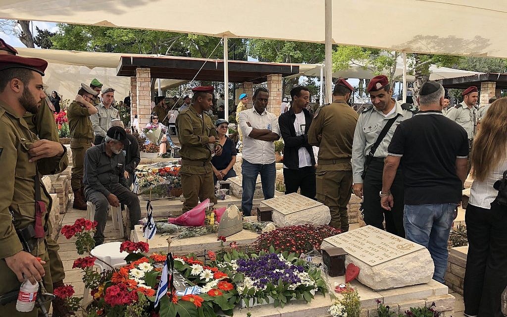 Les membres d'une famille en deuil devant la tombe de leur proche disparu au cimetière militaire d'Ashkelon à Yom HaZikaron, le 8 mai 2019 (Crédit : Jacob Magid/Times of Israel) Les membres d'une famille en deuil devant la tombe de leur proche disparu au cimetière militaire d'Ashkelon à Yom HaZikaron, le 8 mai 2019 (Crédit : Jacob Magid/Times of Israel)