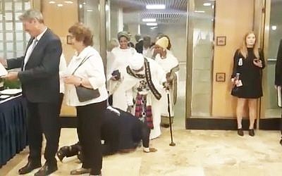 Le député Gadi Yevarkan embrasse les pieds de sa mère, au sol, en signe de gratitude, avant de prêter serment pour devenir officiellement membre de la 21e Knesset. (Crédit : capture d'écran Facebook)