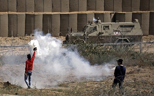 Des émeutiers palestiniens renvoient des grenades de gaz lacrymogène lors d'affrontements avec les forces israéliens lors des manifestations du Jour de la Nakba, à l'est de Bureji dans le centre de la bande de Gaza, le 15 mai 2019. (Thomas COEX / AFP) Des émeutiers palestiniens renvoient des grenades de gaz lacrymogène lors d'affrontements avec les forces israéliens lors des manifestations du Jour de la Nakba, à l'est de Bureji dans le centre de la bande de Gaza, le 15 mai 2019. (Thomas COEX / AFP)