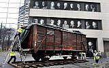 Photo d'illustration : Des portraits de survivants de la Shoah sont exposés au Musée de l'héritage juif alors qu'un ancien wagon allemand, comme ceux utilisés pour transporter des Juifs vers Auschwitz et d'autres camps de la mort, est présenté devant le musée, à New York, le 31 mars 2019. (AP Photo/Richard Drew)