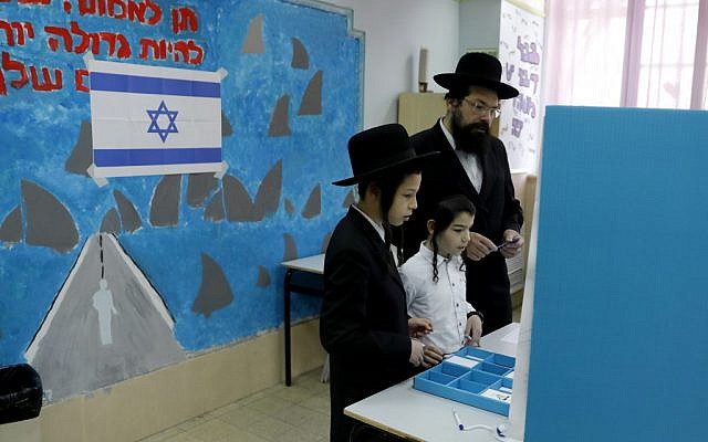 Un juif ultra-orthodoxe se prépare à voter sous le regard d'enfants lors des élections législatives israéliennes du 9 avril 2019 à Jérusalem. (Menahem Kahana/AFP) Un juif ultra-orthodoxe se prépare à voter sous le regard d'enfants lors des élections législatives israéliennes du 9 avril 2019 à Jérusalem. (Menahem Kahana/AFP)