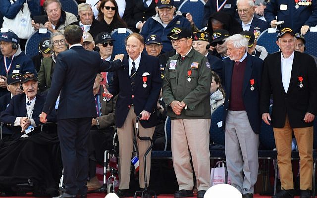 Le président français Emmanuel Macron salue des vétérans américains après leur avoir remis la Légion d'Honneur au cimetière américain de Coleville sur mer, le 6 juin 2019. (Crédit : Damien MEYER / AFP) Le président français Emmanuel Macron salue des vétérans américains après leur avoir remis la Légion d'Honneur au cimetière américain de Coleville sur mer, le 6 juin 2019. (Crédit : Damien MEYER / AFP)