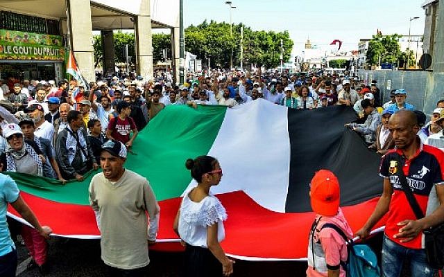 Des manifestants scandent des slogans et agitent un drapeau palestinien géant lors d'une manifestation à Rabat, la capitale marocaine, le 23 juin 2019 contre la conférence économique organisée à Bahreïn par les États-Unis. (Crédit photo : AFP) Des manifestants scandent des slogans et agitent un drapeau palestinien géant lors d'une manifestation à Rabat, la capitale marocaine, le 23 juin 2019 contre la conférence économique organisée à Bahreïn par les États-Unis. (Crédit photo : AFP)