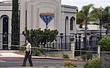 Un shérif adjoint du comté de San Diego se tient devant la synagogue Habad à Poway, en Californie, le 28 avril 2019, après une fusillade. (Crédit : AP/Denis Poroy)