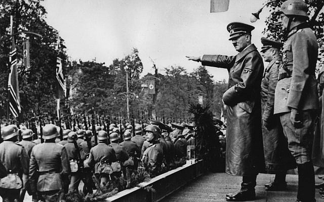 Adolf Hitler, (au centre), saluant les troupes de la Wehrmacht allemande qui défilent à Varsovie, en Pologne, au mois d'octobre 1939, après l'invasion allemande. Derrière, de gauche à droite : Le commandant en chef de l'armée, le Colonel Général Walther von Brauchitsch, le nouveau commandant de Varsovie, le Lieutenant Général Friedrich von Cochenhausen, le Colonel Général Gerd von Rundstedt, le Colonel Général Wilhelm Keitel. (Crédit : AP Photo) Adolf Hitler, (au centre), saluant les troupes de la Wehrmacht allemande qui défilent à Varsovie, en Pologne, au mois d'octobre 1939, après l'invasion allemande. Derrière, de gauche à droite : Le commandant en chef de l'armée, le Colonel Général Walther von Brauchitsch, le nouveau commandant de Varsovie, le Lieutenant Général Friedrich von Cochenhausen, le Colonel Général Gerd von Rundstedt, le Colonel Général Wilhelm Keitel. (Crédit : AP Photo)