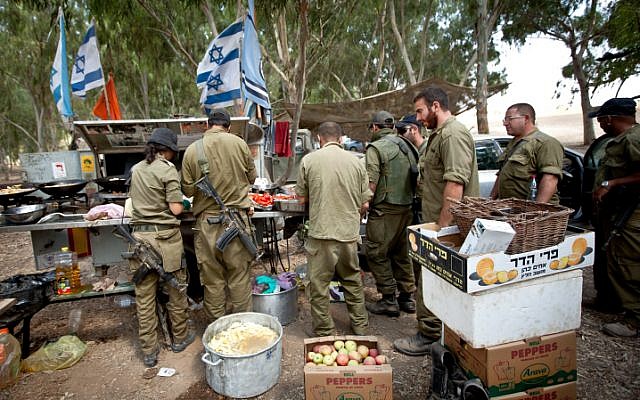 A titre d'illustration : Des soldats de réserve de Tsahal en train de recevoir de la nourriture dans une zone de transit près de la frontière avec Gaza, dans le sud d'Israël, le 20 juillet 2014, lors de l'opération Bordure protectrice menée par Israël. (Moshe Shai/Flash90)