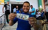 Les Palestiniens reçoivent leur aide financière dans le cadre d'une aide de 480 millions de dollars allouée par le Qatar, dans un bureau de poste de la ville de Gaza, le 19 mai 2019. (Abed Rahim Khatib/Flash90)