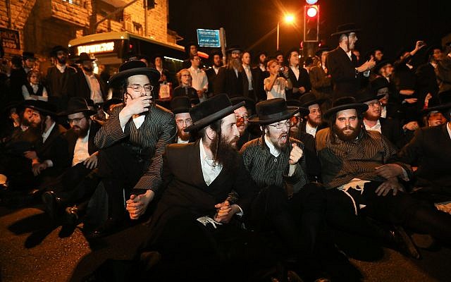 Des hommes ultra-orthodoxes affrontent la police lors d'une manifestation dénonçant l'arrestation de femmes haredim ne s'étant pas présentées au service militaire, à Jérusalem, le 24 juin 2019. (Crédit : Noam Revkin Fenton/Flash90) Des hommes ultra-orthodoxes affrontent la police lors d'une manifestation dénonçant l'arrestation de femmes haredim ne s'étant pas présentées au service militaire, à Jérusalem, le 24 juin 2019. (Crédit : Noam Revkin Fenton/Flash90)