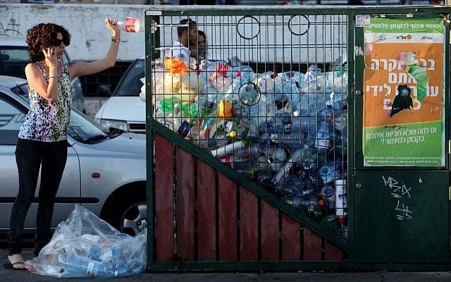 Une femme jette une bouteille dans un bac de recyclage du centre de Jérusalem. (Crédit photo : Nati Shohat/Flash90) Une femme jette une bouteille dans un bac de recyclage du centre de Jérusalem. (Crédit photo : Nati Shohat/Flash90)