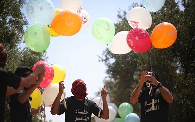 Des jeunes Palestiniens préparent des ballons incendiaires à envoyer en Israël à l'est du camp de réfugiés de Bureij, dans la bande de Gaza, le 31 mai 2019 (Crédit : Hassan Jedi/ Flash90) Des jeunes Palestiniens préparent des ballons incendiaires à envoyer en Israël à l'est du camp de réfugiés de Bureij, dans la bande de Gaza, le 31 mai 2019 (Crédit : Hassan Jedi/ Flash90)