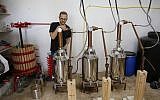 Le distillateur américano-palestinien Nader Muaddi attend que l'alcool soit distillé dans le village de Beit Jala, en Cisjordanie, près de Bethléem, le 16 juin 2019. (Crédit : HAZEM BADER / AFP)