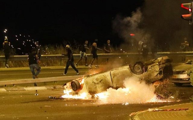 Une voiture de police brûle alors que des membres de la communauté éthiopienne en Israël affrontent la police dans la ville côtière israélienne de Netanya le 2 juillet 2019, lors d'une manifestation contre le meurtre de Solomon Tekah, un jeune homme d'origine éthiopienne, tué par un policier qui n'était pas en service. (Photo par JACK GUEZ / AFP) Une voiture de police brûle alors que des membres de la communauté éthiopienne en Israël affrontent la police dans la ville côtière israélienne de Netanya le 2 juillet 2019, lors d'une manifestation contre le meurtre de Solomon Tekah, un jeune homme d'origine éthiopienne, tué par un policier qui n'était pas en service. (Photo par JACK GUEZ / AFP)