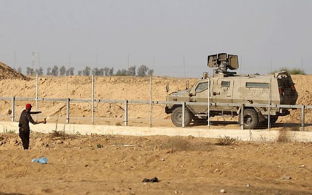 Un manifestant palestinien jette un cocktail molotov vers un véhicule militaire israélien durant des manifestations le long de la frontière avec Israël, à l'est de Khan Yunis, dans le sud de la bande de Gaza, le 5 juillet 2019 (Crédit : SAID KHATIB / AFP) Un manifestant palestinien jette un cocktail molotov vers un véhicule militaire israélien durant des manifestations le long de la frontière avec Israël, à l'est de Khan Yunis, dans le sud de la bande de Gaza, le 5 juillet 2019 (Crédit : SAID KHATIB / AFP)