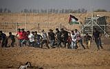 Des manifestants palestiniens fuient la clôture pendant les manifestations le long de la frontière avec Israël, à l'est de Khan Younis, dans le sud de Gaza, le 12 juillet 2019 (Crédit : Mahmud Hams/AFP)