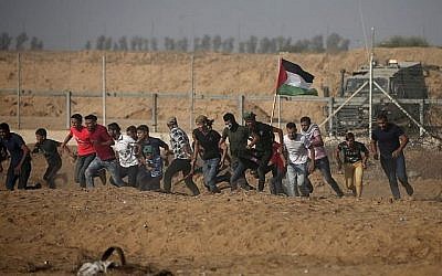 Des manifestants palestiniens fuient la clôture pendant les manifestations le long de la frontière avec Israël, à l'est de Khan Younis, dans le sud de Gaza, le 12 juillet 2019 (Crédit : Mahmud Hams/AFP)