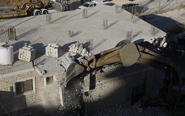 Les forces de sécurité israéliennes démolissant les bâtiments palestiniens encore en construction qui ont fait l'objet d'avis de démolition dans la zone de Wadi al-Hummus adjacente au village palestinien de Sur Baher à Jérusalem-Est, 22 juillet 2019. (Ahmad GHARABLI / AFP)