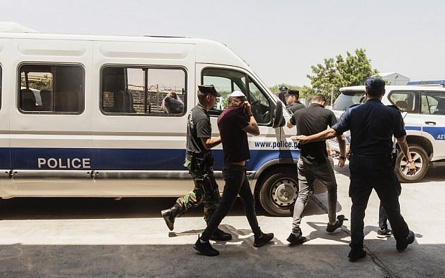 Des touristes israéliens, soupçonnés d'avoir violé une jeune Britannique de 19 ans à Ayia Napa, quittent les locaux du tribunal dans la station balnéaire chypriote orientale de Paralimni, le 26 juillet 2019. (Iakovos Hatzistavrou / AFP)