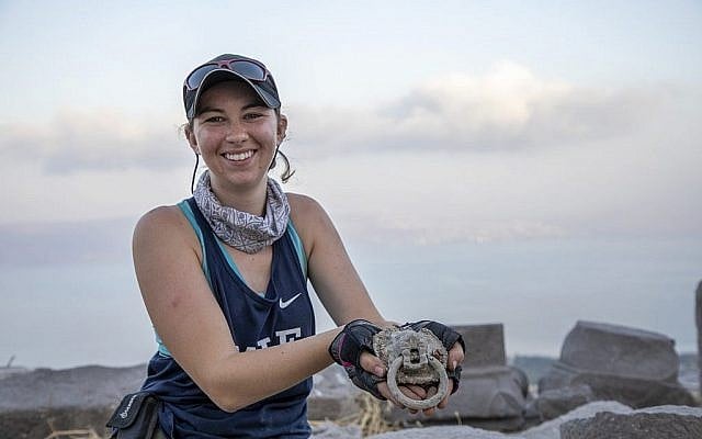 Jessica Rentz, responsable du site, montre un heurtoir à tête de lion découvert à "l'église brûlée" dans le cadre du projet de fouilles Hippos-Sussita au parc national Susita à l'été 2019. (Autorisation)