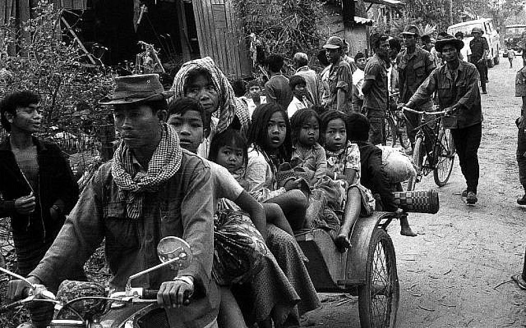 Au mois de janvier 1974, des Cambodgiennes et des enfants se rendent en moto-taxi vers des endroits plus sûrs de Phnom Penh alors que les Khmers Rouges continuent à frapper la capitale (Crédit : AP Photo)