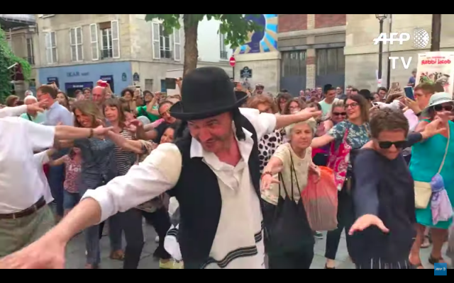46 ans après la sortie du film avec Louis de Funès, un flashmob a réuni mercredi 10 juillet quelques 200 fans qui ont reconstitué la célèbre scène de la danse traditionnelle au cœur du quartier juif de Paris. (Crédit photo : capture d’écran vidéo AFP / YouTube)