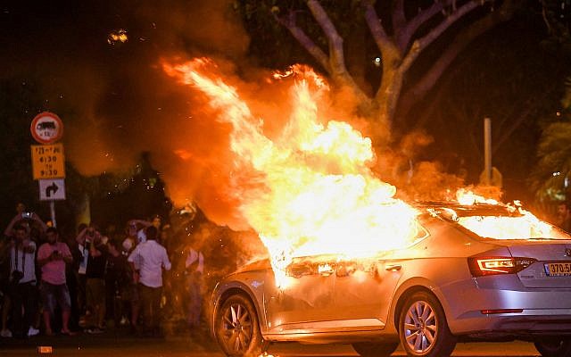 Une voiture en feu pendant une manifestation après la mort de Solomon Tekah, un Israélien d'origine éthiopienne abattu par un policier, à Tel Aviv, le 2 juillet 2019. (Crédit : Flash90) Une voiture en feu pendant une manifestation après la mort de Solomon Tekah, un Israélien d'origine éthiopienne abattu par un policier, à Tel Aviv, le 2 juillet 2019. (Crédit : Flash90)