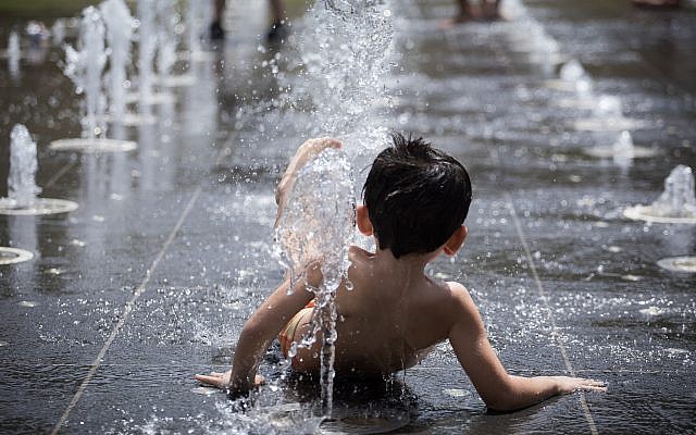 De jeunes enfants jouent dans le miroir d'eau du parc Teddy à Jérusalem en pleine vague de chaleur dans tout le pays, le 17 juillet 2019. (Crédit : Hadas Parush/Flash90) De jeunes enfants jouent dans le miroir d'eau du parc Teddy à Jérusalem en pleine vague de chaleur dans tout le pays, le 17 juillet 2019. (Crédit : Hadas Parush/Flash90)