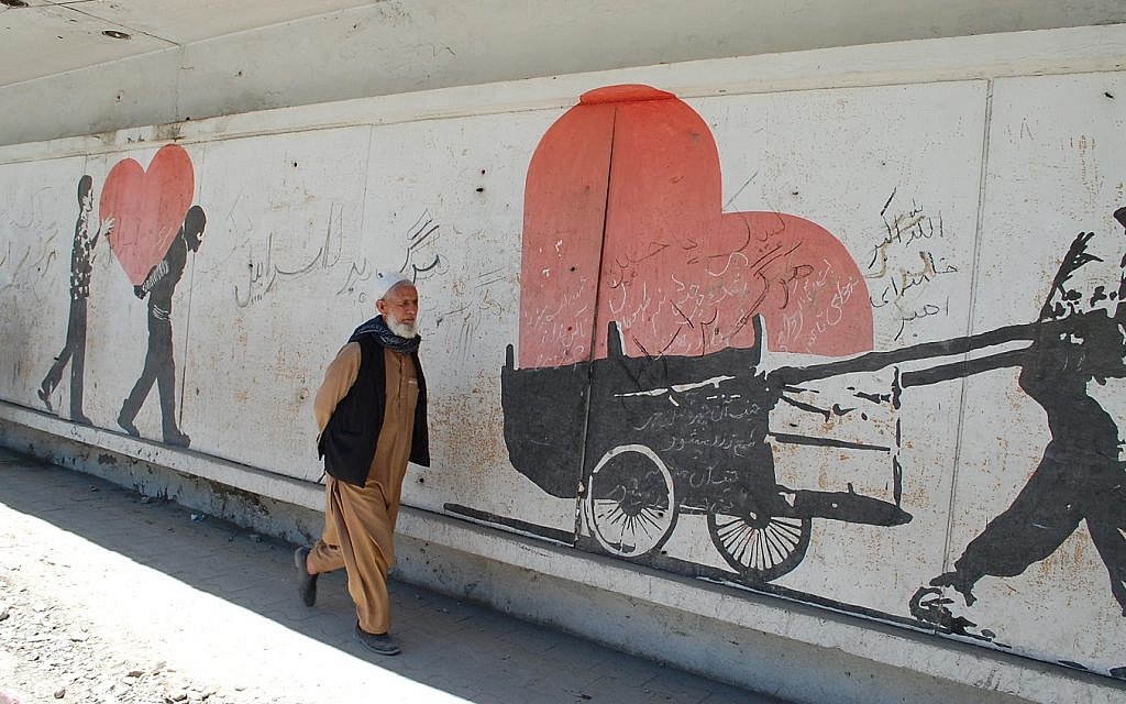 Un homme afghan à Kaboul passe devant une peinture murale sur le site d'une attentat à la bombe, où l'on peut lire des slogans gribouillés de "mort à Israël".(Ezzatullah Mehrdad/ Times of Israël) Un homme afghan à Kaboul passe devant une peinture murale sur le site d'une attentat à la bombe, où l'on peut lire des slogans gribouillés de "mort à Israël".(Ezzatullah Mehrdad/ Times of Israël)