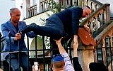 Le grand rabbin polonais Michael Schudrich grimpe sur la clôture d'une synagogue barricadée (Crédit : Shimon Briman/JTA)